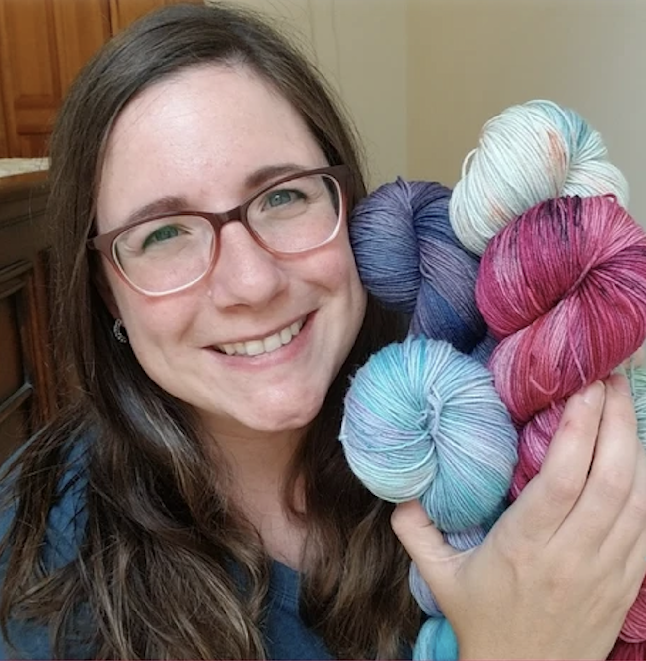 Granite State Yarns dyer holding colorful skeins of yarn